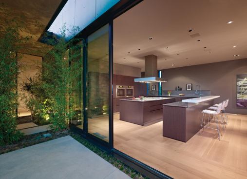 The kitchen occupies a canted, bar-shaped wing perpendicular to the living area.