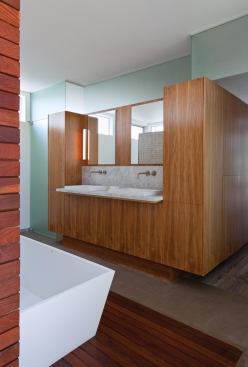 A walnut millwork “box” separates the bath from the master bedroom.