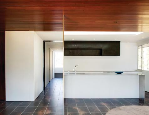 Stainless steel columns—so slender that they are practically two-dimensional—mark the path of the partition that isolated the original kitchen from the living and dining areas.
