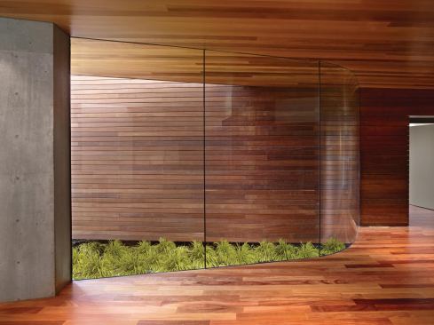 Between the addition's two volumes lies a narrow garden integrated into the house by a curved glass wall.