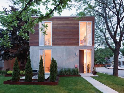 A cast-in-place concrete system forms the walls of the first floor and garden, while wood siding clads the upper level.