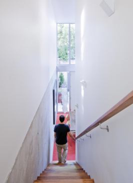 Exposed concrete serves as both a structural and finish material for the first level. Upstairs, plaster walls convey a contrasting sense of lightness.