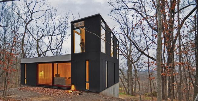 Covered in black plaster, the home is vertical to minimize its footprint.