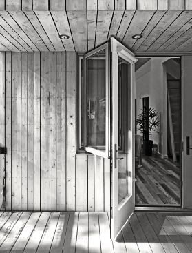 The casement window and terrace doors on the rear deck provide views to the forest.