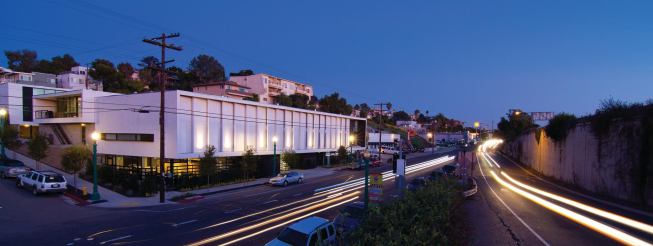 The project steps down a sloping site and contains 5,000 square feet of retail on its east side. Plaster fins deflect sounds from the nearby freeway.