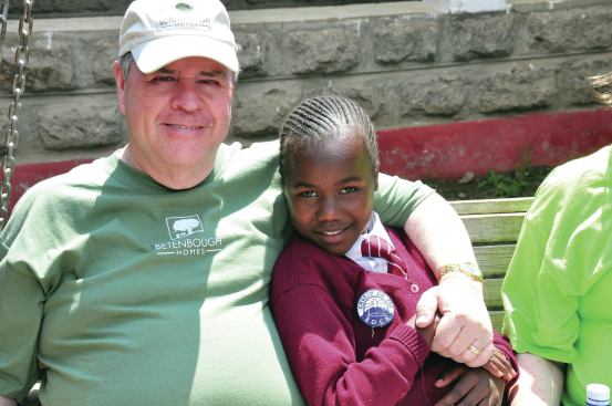 Vice president Ron Betenbough hugs a child sponsored by the company at the Kenyan orphanage.
