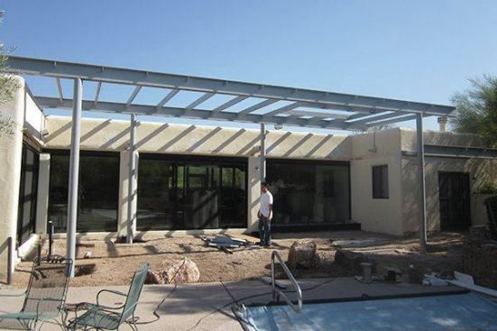 A during photo of the project shows the construction of the steel canopy frame.