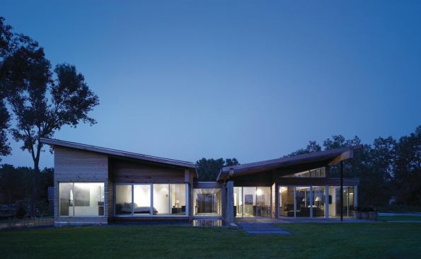 The master suite, visible at left, is a high-ceilinged, linear space that terminates in a room-width window.