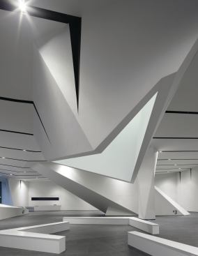 A skylit atrium extends through the building, terminating in an articulated aperture over a seating area in the ground-floor gallery. 