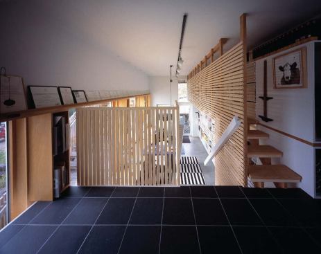 Unfinished basswood strips screen the office’s upstairs and mezzanine level.