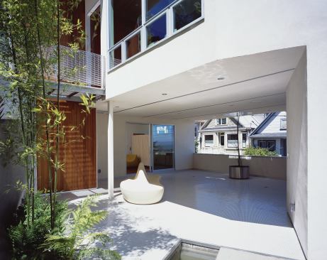 Two floors below, a sheltered outdoor space tunnels through the building, joining its private and public sides.