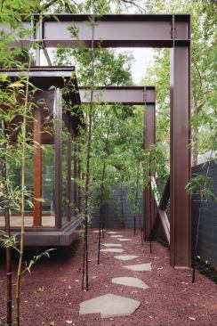 Bamboo stands and a truss canopy create a sense of journey to the entryway.