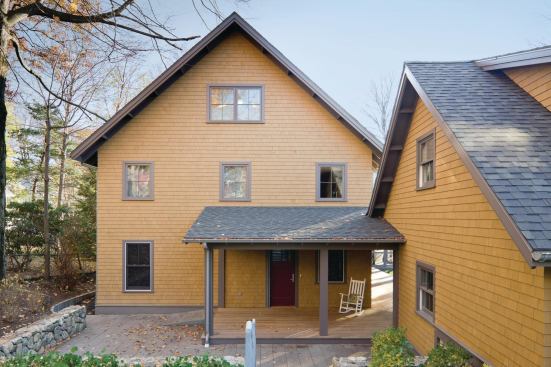 A wraparound porch connects the courtyard to the main entry, while the garage, at right, is detached but accessible by a covered walkway. Because the family’s minivan often runs for long periods while the wheelchair lift system is operating, the owners wanted to ensure that pollutants
from the car would not enter the home. A bluestone ramp and sloped path, at left,
lead to the lower backyard.