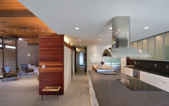 Individual rooms in this open plan are differentiated through the use of varied ceiling heights and finishes.