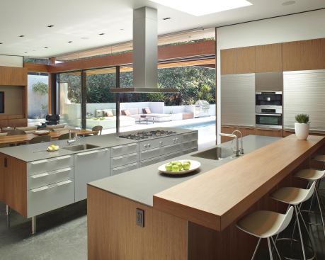 Oriented toward a family room/screening room and open to an outdoor pool deck, this kitchen balances illumination with a large skylight over its work area.