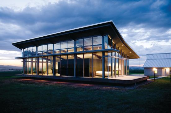 The house sits on a platform to give the impression of floating on its vast, grassy site.