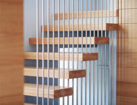 The stainless steel rods are joined by threaded couplings hidden within the thickness of the wood.