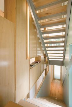 A first draft of the design called for stairs in a bump-out on the tower. But budget constraints dictated that the stairs remain inside the tower. The team at KUBE used a two-sided bookcase to separate the stairs.
