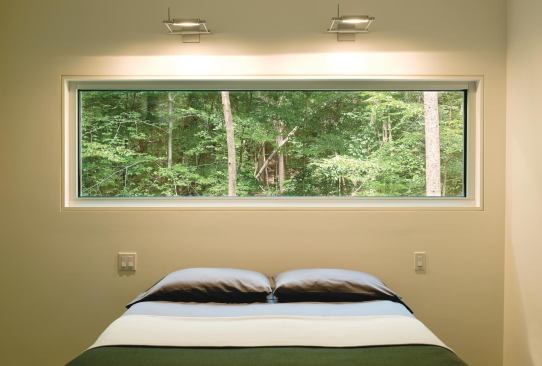 The view through this master bedroom window resembles a painting of a forest, architect Janet Bloomberg says.