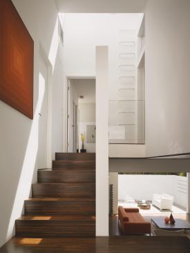 The rear stairs wrap around to the private areas of the house. Steel rungs lead to a skylight that brings additional light to the back of the house and provides access to the rooftop.