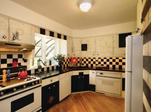 Kitchen cabinets had their front faces stripped and then refinished with encaustic medium and used as a canvas for the homeowner's artistic expression.