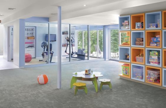 Designer Joe Eisner and remodeler Michael Amnon transformed a dreary basement into a light-filled family hub, adding a home office, gym, bar and lounge, guest bedroom, bathroom, storage, and large play area to this Westchester County, N.Y., home. 