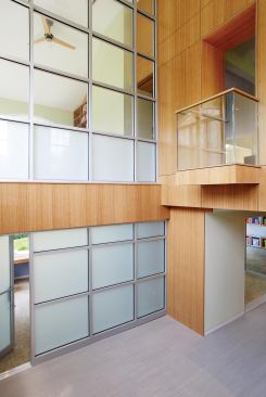 The double-sided/double-height bamboo paneled wall acts as a new vertical focal point to what was a generic house layout.