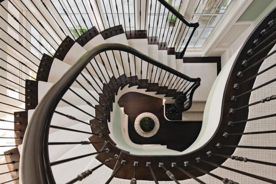 The treads on this dramatic traditional staircase are made of custom wide-plank character oak.