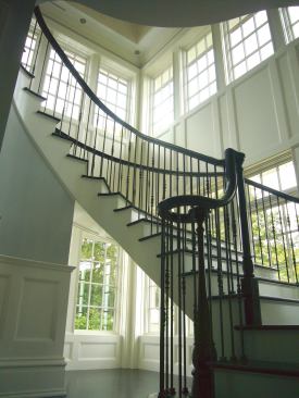A custom decorative balustrade with a cast iron shoe adds a finishing touch to the staircase design.