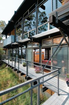 Glass walls along the east side of the house take advantage of surrounding views. There are three levels of aluminum grating decks.