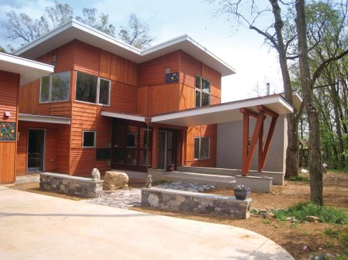 The original 1970s house lacked a style and was clad in baby-blue vinyl siding. However, the house was in a great location on the site and to conserve natural resources, the owners and designer decided to preserve the original house as the core of the remodeled structure and add two wings.