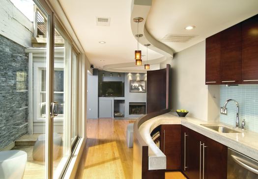 The kitchen faces the open outdoor courtyard. The doors slide back for a large opening for easy access to the exterior.