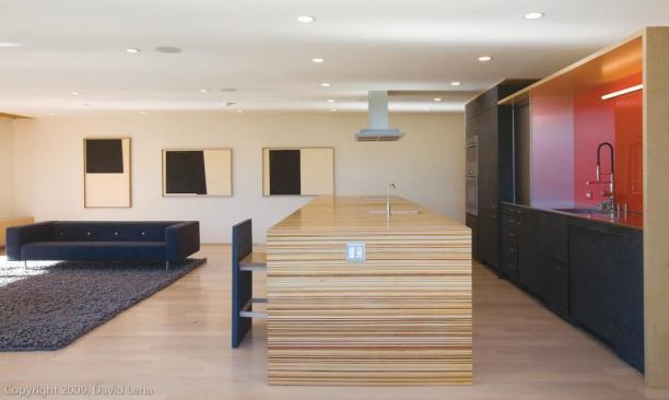 The designers signature is a kitchen island with integral stools that resemble cabinet doors when pushed in to the base. Erla Ingjaldsdottir did not use tile or carpet in the house.