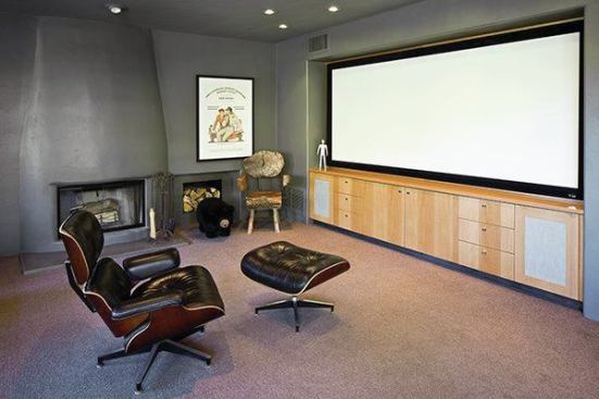 Architect Rob Paulus incorporated the original fireplace in to the theater room wall. The large projection screen takes up one wall.