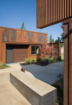 Scored concrete, raised beds, and sitting areas direct the path to the front door.