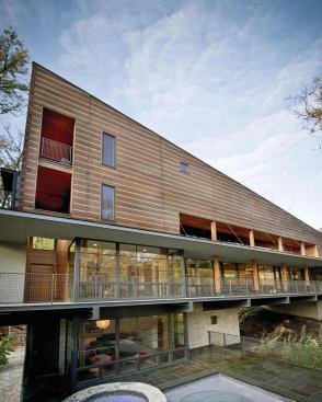 A northeast-facing terrace and double-height glass is incised into the log wall.