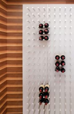 The wine bottles are mounted on translucent panels that glow at night.