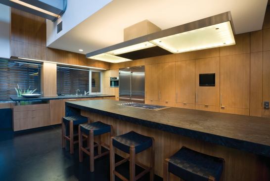 Light filters down into the kitchen through clerestories and the glass bridge.