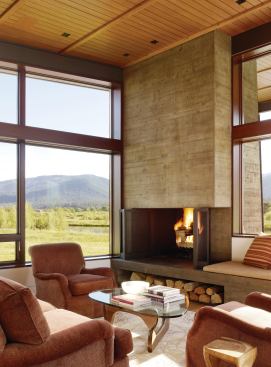 A concrete fireplace anchors the glass living room.