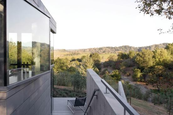 Interior and exterior living spaces take in long views over an olive grove.

