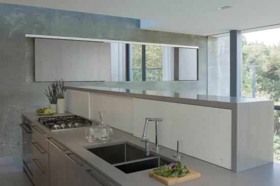 The kitchen overlooks the living area. A sliding screen beyond opens a window into the bedroom.

