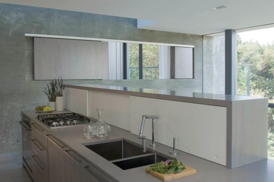 The kitchen overlooks the living area. A sliding screen beyond opens a window into the bedroom.


