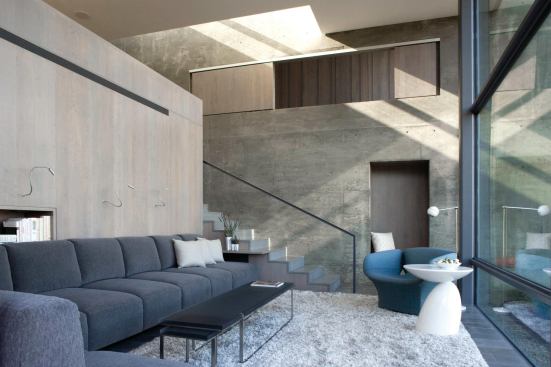 The concrete wall that slices through the building opens for a windowed seating nook in the living room.

