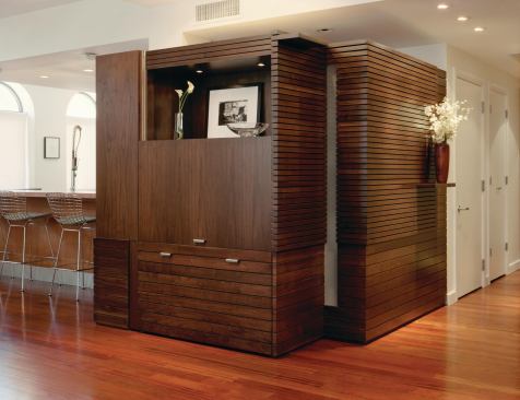 The walnut-stained casework in this New York City loft includes a toy closet, kitchen pantry, desk, and bench, in addition to a media center and closets.