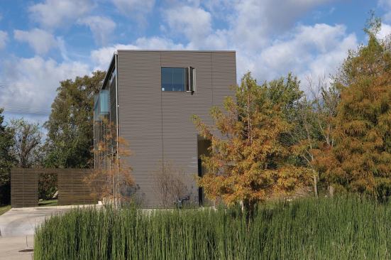 On the facade of Ford Trimotor House, a 1,900-square-foot residence in Dallas' Urban Reserve development, vertical metal bands humanize the scale of the corrugated metal walls.