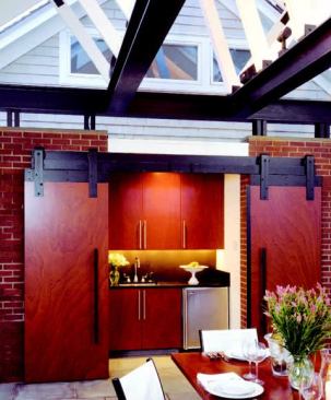A small outdoor kitchen can be hidden behind barn doors.