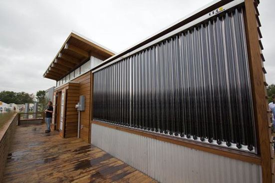 The vertical installation of collection panels for the solar hot water system encloses the entry space to all but one view.