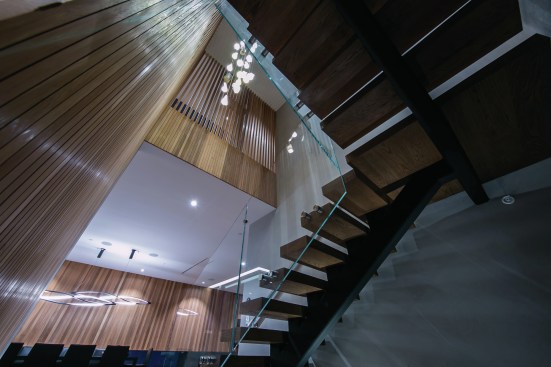 Decorative wood shutter fixtures scatter light on the floating stairwell.