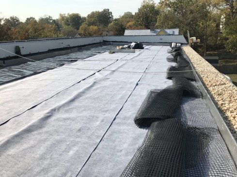 Stainless steel leak detection mesh lays on the roof ready to be spread out.