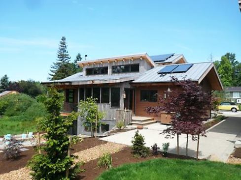 The house, here viewed from the rear garden, sits lightly on the land and blends well with the eclectic flavor of the existing neighborhood.